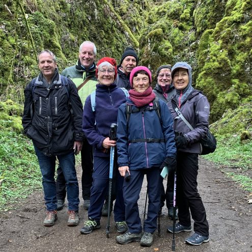 Gruppenbild mit sieben Wanderern vor vermoosten Felsen